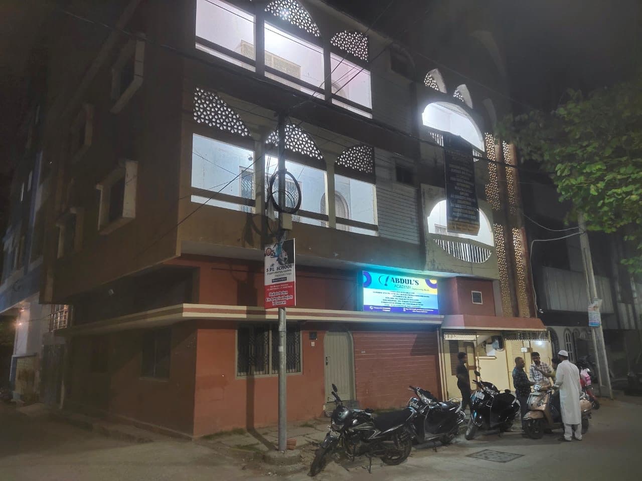 The academy building on New Malakpet in the evening, its signboard lit