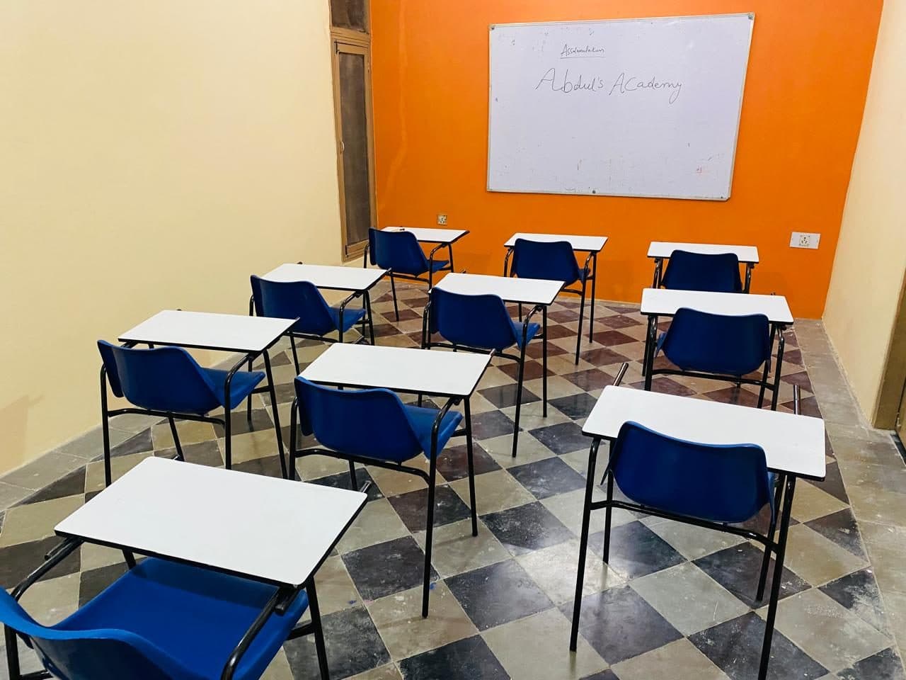 Desks and chairs set out in a classroom before a batch